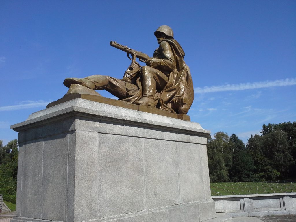 Pic 6 - Statue of a Soviet soldier. Mass graves are in the background.